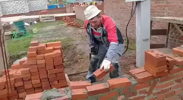 Мужик кладет кирпич