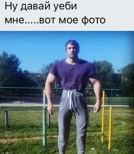 Мужчина стоит неподвижно в полный рост на фоне турников. — мужчина спортивного телосложения с неестественно широкими плечами