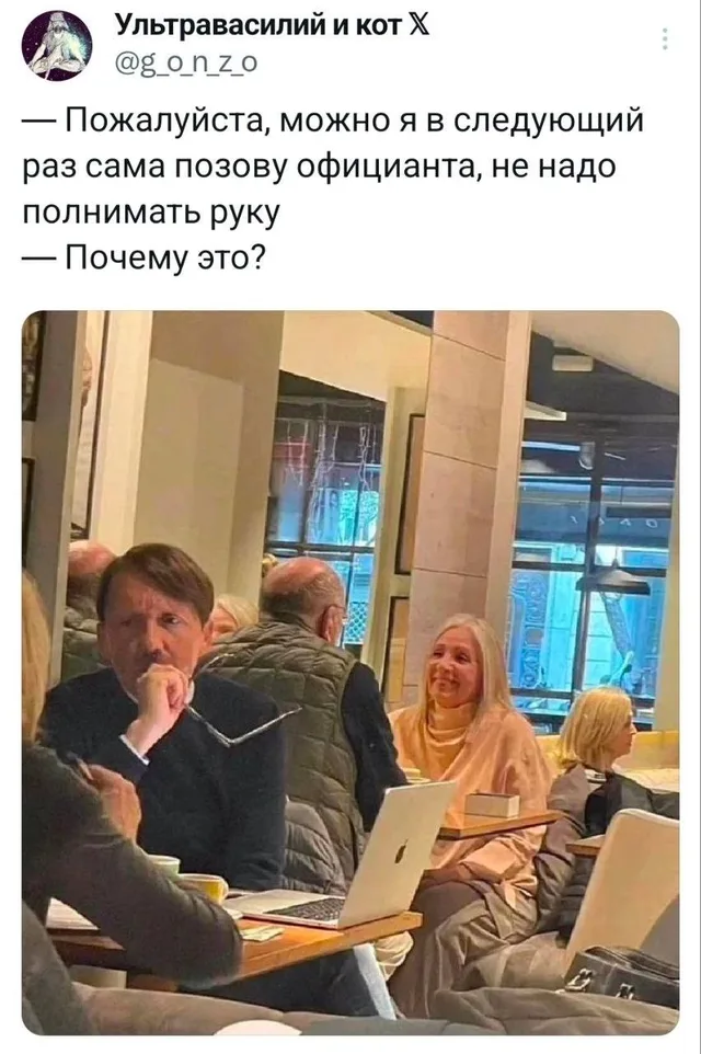 Мужчина и женщина сидят за столиком в ресторане, мужчина держит очки, женщина улыбается. — мужчина в темном свитере, женщина со светлыми вол
