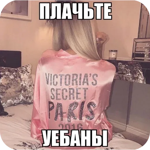 Девушка сидит в расслабленной позе, демонстрируя спину с брендовой надписью — девушка в розовой куртке