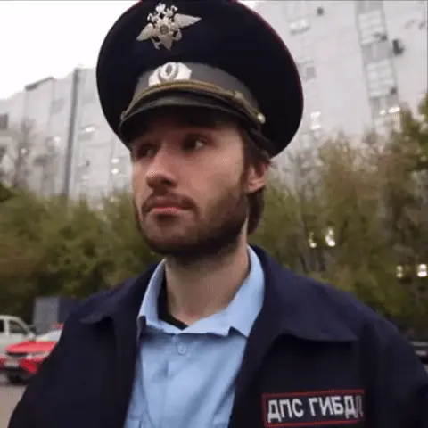 Мужчина смотрит в камеру, делает рукой жест «позвони мне» (прикладывает большой палец и мизинец к уху) и слегка кивает. — Алексей Деревяшкин