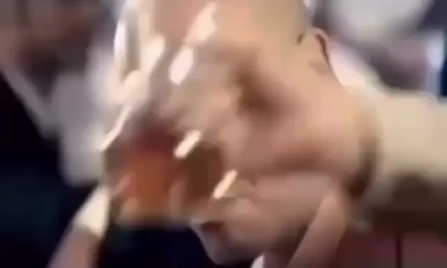 Лысый мужчина подмигивает в ресторане