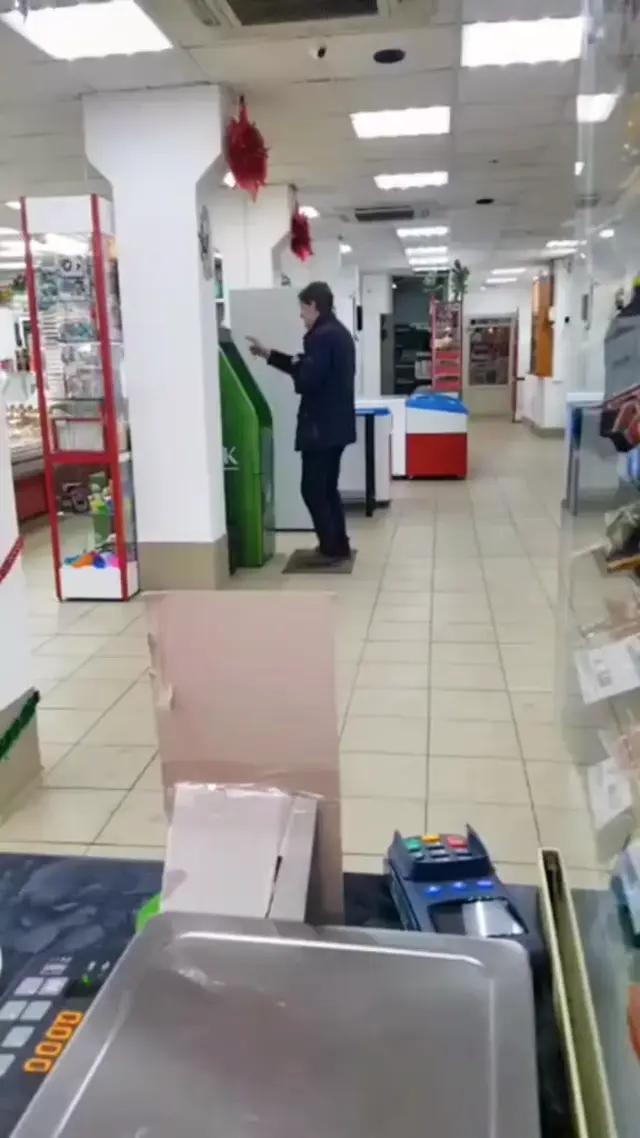 Мужчина танцует у банкомата