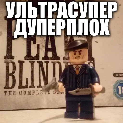 Фигурка стоит неподвижно, удерживая оружие в обеих руках. — фигурка LEGO в стиле персонажа «Острых козырьков»