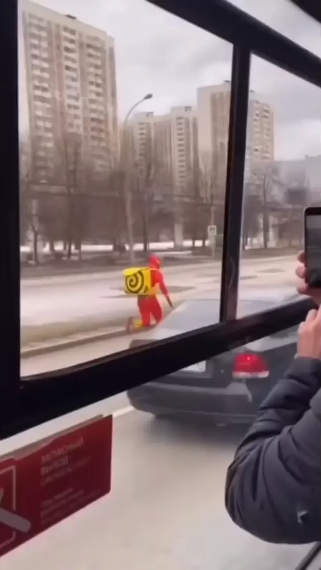 Курьер Яндекс Еды в костюме Флэша бежит за автобусом