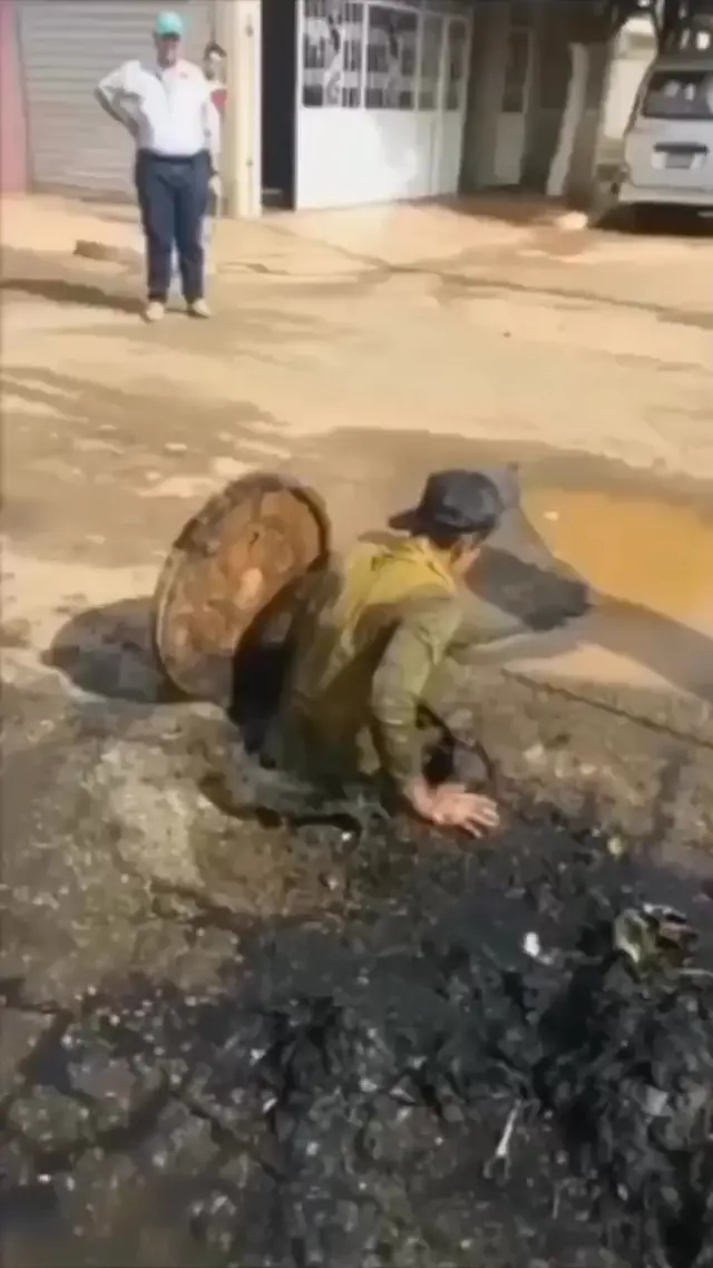 Парень вылезает из грязного люка
