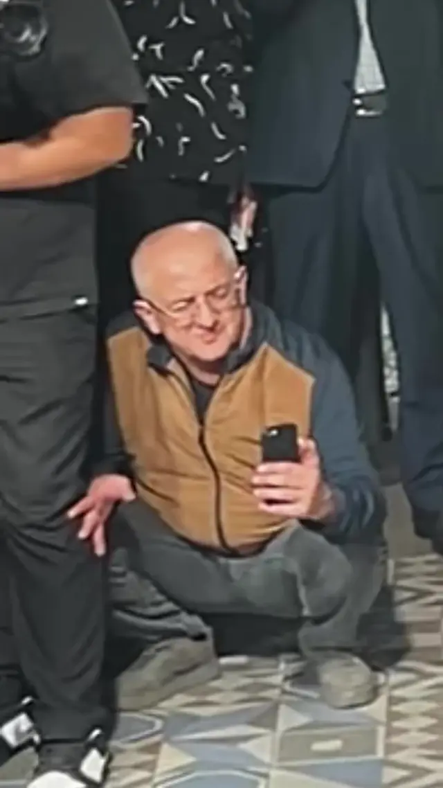 Мужчина на корточках снимает невесту