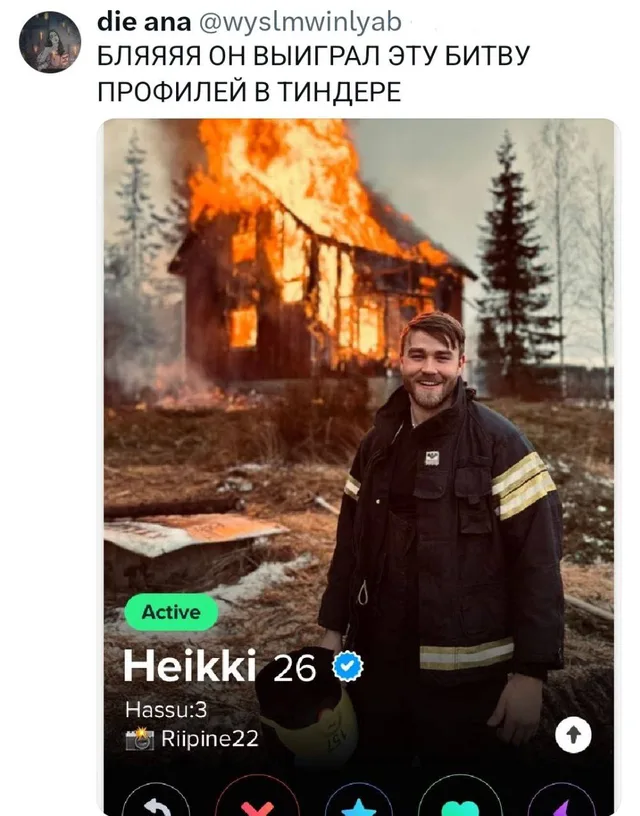 Мужчина в пожарной экипировке стоит на переднем плане, позади него полыхает деревянный дом. — Heikki