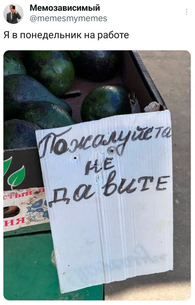 Скриншот поста из соцсети. На фото изображена картонная табличка с надписью от руки, прикрепленная к ящику с авокадо на рынке или в магазине
