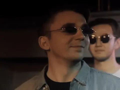 Парень в узких очках улыбается и кивает