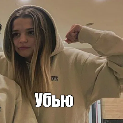 Статичное изображение, девушка позирует с поднятым кулаком — Юля Гаврилина, девушка в бежевом худи
