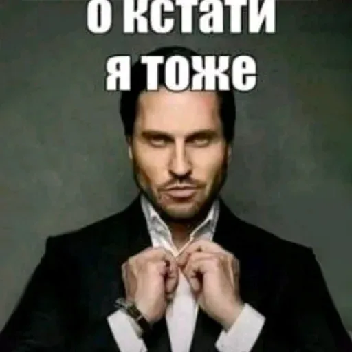 Мужчина поправляет воротник рубашки, глядя в объектив. — Александр Ревва, мужчина в костюме