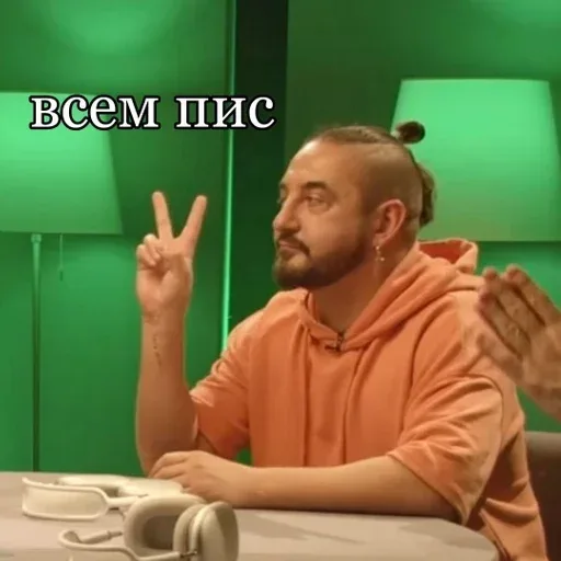 Человек сидит неподвижно, удерживая пальцы в жесте «V» (мир). — Сергей Матвиенко