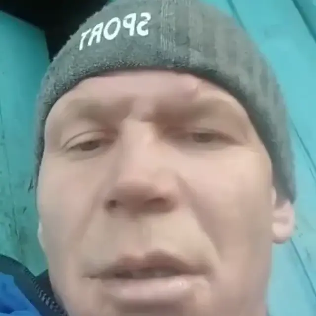 Мужчина в шапке Sport смотрит в камеру