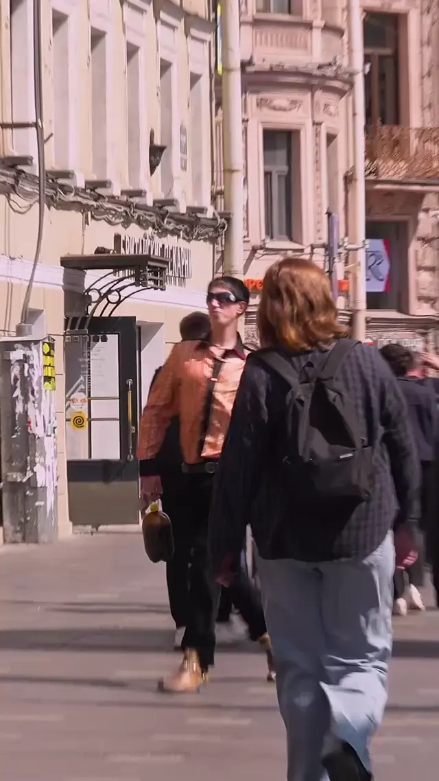 Парень в золотых туфлях танцует с пивом на улице
