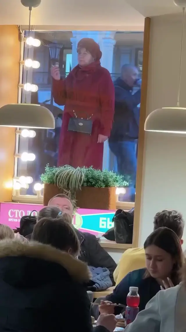 Женщина в красном пальто курит под Аль Капоне