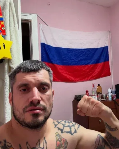Паша Техник демонстрирует бицепс, сгибая руку в локте, при этом сохраняя невозмутимое выражение лица. — Паша Техник