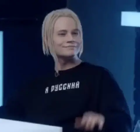 Человек улыбается, кивает и делает пренебрежительный жест рукой, словно отмахиваясь от чего-то несерьезного. — SHAMAN (Ярослав Дронов), SHAM