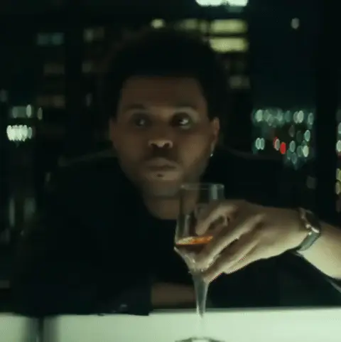 The Weeknd поворачивает голову, осматривая пространство вокруг, после чего переводит взгляд на бокал в своей руке. — The Weeknd