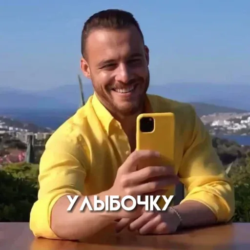 Мужчина держит телефон перед собой, имитируя процесс съемки селфи или записи видео. — Керем Бюрсин