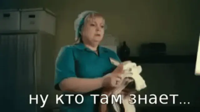Женщина стоит на месте, слегка перебирает руками стопку одежды, глядя в камеру с выражением сомнения. — женщина в синей униформе