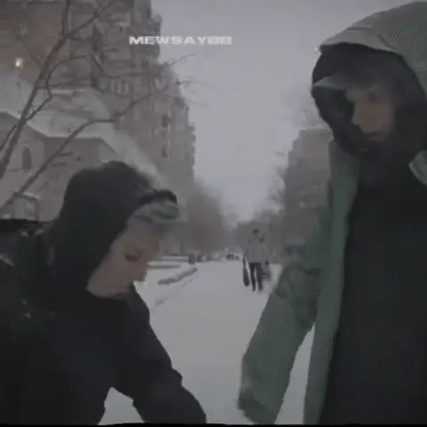 Человек сидит в снегу, смотрит в небо и артикулирует слова, в то время как мимо проходит другой человек. — человек с пепельно-голубыми волос