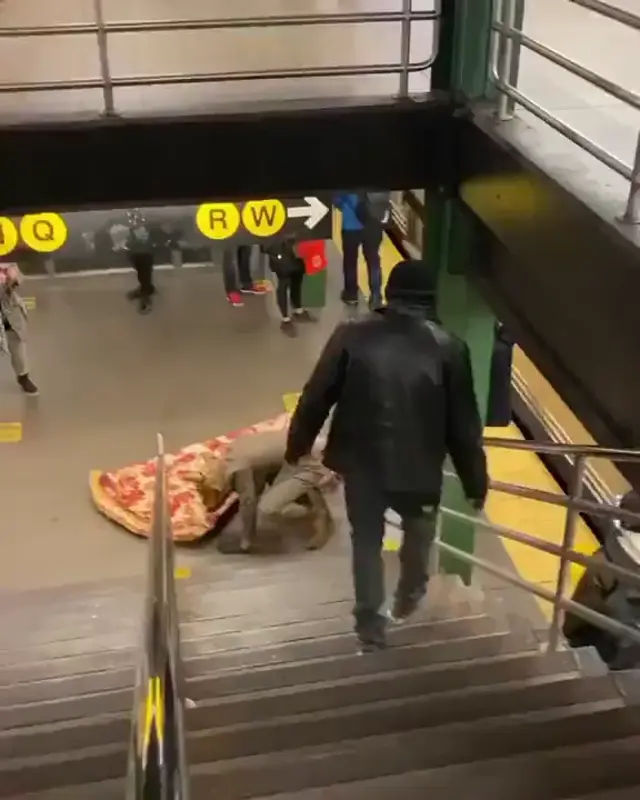 Крыса тащит гигантскую пиццу по лестнице в метро