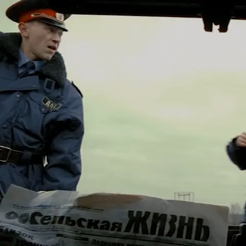 Сергей Горобченко жестикулирует, пытаясь что-то доказать, в то время как один из сотрудников ДПС убирает документы или кошелек в карман. — С