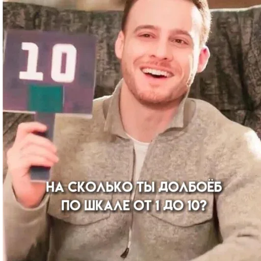 Мужчина держит табличку с числом «10» перед собой, демонстрируя её камере. — Керем Бюрсин