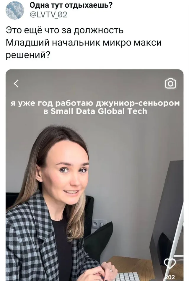 Женщина сидит за столом перед монитором, руки лежат на клавиатуре. — женщина в клетчатом пиджаке