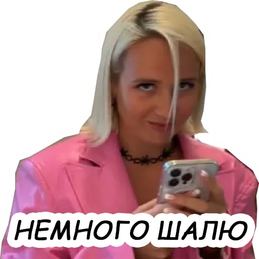 Девушка смотрит в экран телефона с хитрым выражением лица. — девушка со светлыми волосами в розовом пиджаке