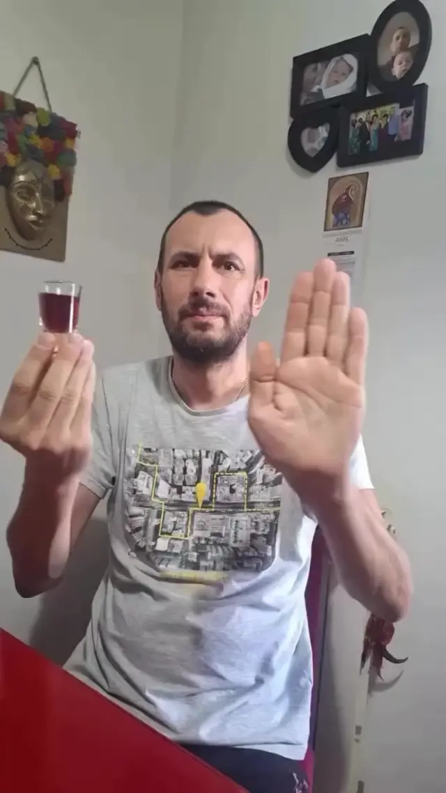 Мужчина держит стопку в одной руке, другой рукой делает резкие движения перед лицом, имитируя магические пассы или «исчезновение» стопки, по