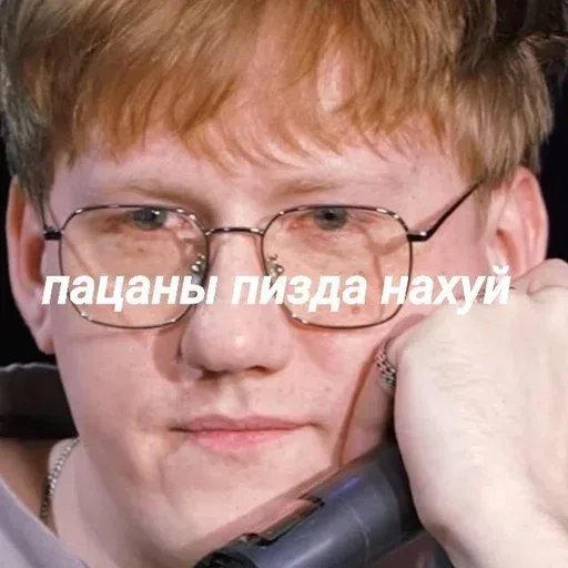 Статичное изображение, человек просто смотрит в камеру. — молодой человек с рыжими волосами в очках