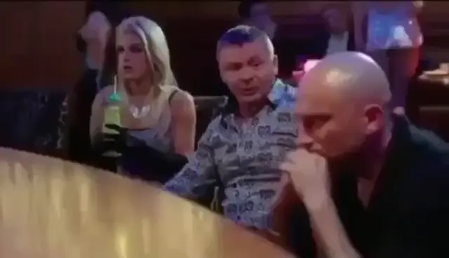 Мужчина в узорчатой рубашке размахивает рукой, объясняя жизненную мудрость, а собеседник угрюмо слушает. — мужчина в узорчатой рубашке, лысы