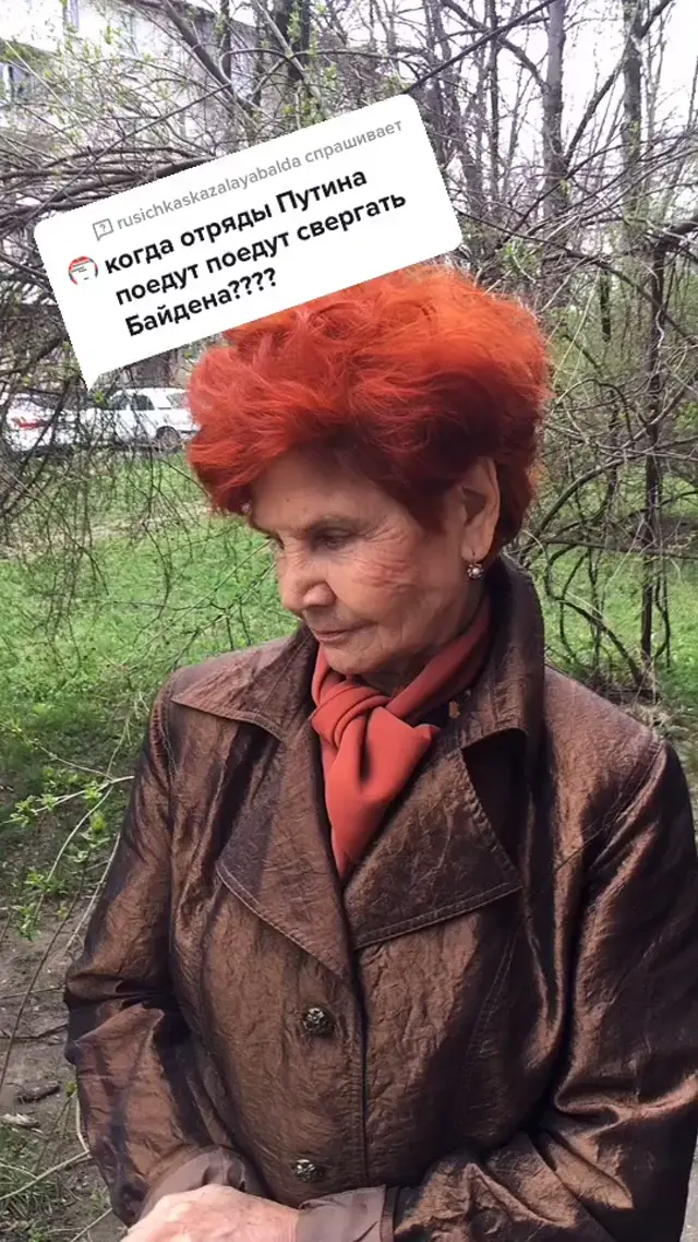 Женщина стоит перед камерой, произносит серьезную фразу про отряды Путина и Байдена — женщина с рыжими волосами