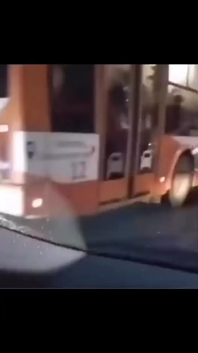 Девушка пытается остановить колесо автобуса