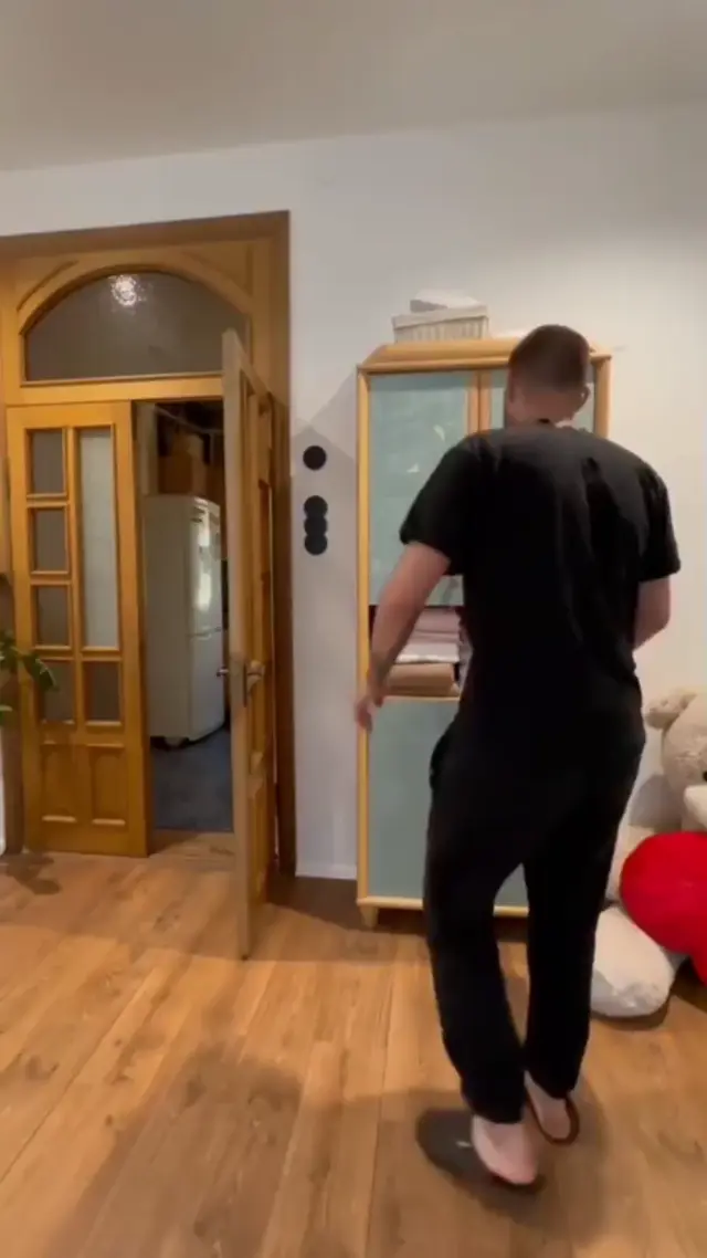 Мужчина в ярости бьет одеждой по шкафу