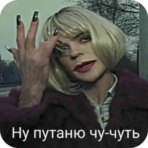 Статичное изображение, персонаж позирует с поднятой рукой. — человек в парике и женском образе