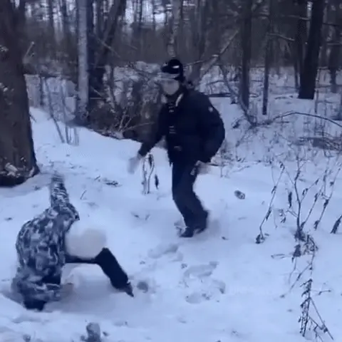 Человек в черной куртке делает резкий захват и бросок через бедро (или подсечку) человека в светлой куртке, после чего оба падают в глубокий