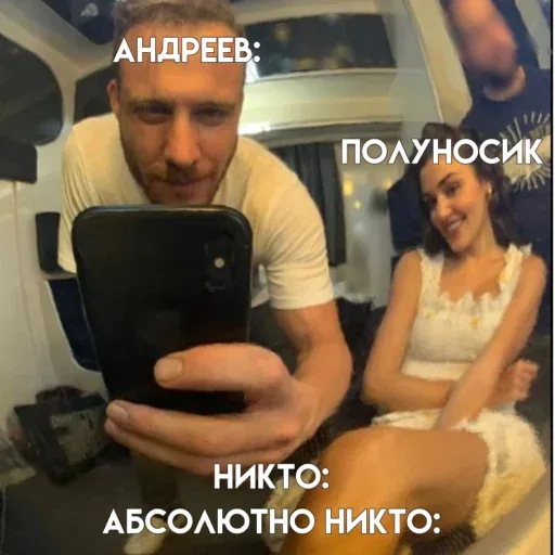Мужчина держит телефон перед собой, снимая селфи, женщина позирует рядом. — Керем Бюрсин, женщина в белом платье