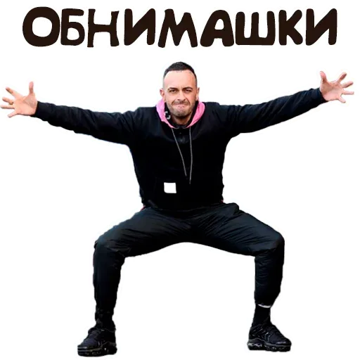 Мужчина стоит в позе, имитирующей готовность к объятиям, широко раскинув руки — мужчина в черной толстовке с розовым капюшоном