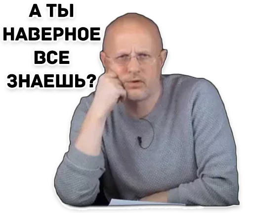 Мужчина сидит неподвижно, глядя в камеру с выражением легкого скепсиса. — Дмитрий Пучков