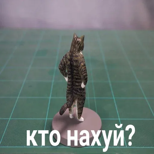 Фигурка полосатого кота стоит на задних лапах спиной к зрителю на круглой подставке — Фигурка полосатого кота