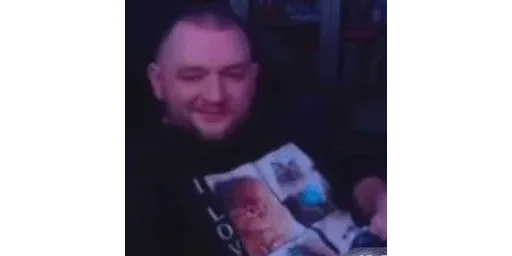 Мужчина сидит неподвижно, улыбаясь в камеру. — Кузьма (KuzyaMeduzya), мужчина с бородой в футболке с котиками