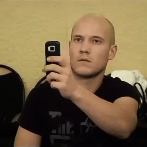 Лысый парень снимает на телефон