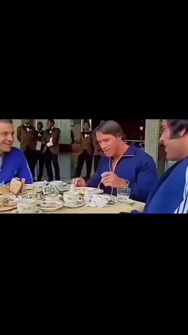 Арнольд Шварценеггер ест и смеется в синем спортивном костюме