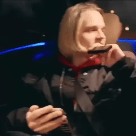 Человек сидит неподвижно, прижимая телефон к уху, периодически слегка меняя наклон головы и взгляд, сохраняя одну и ту же скептичную гримасу