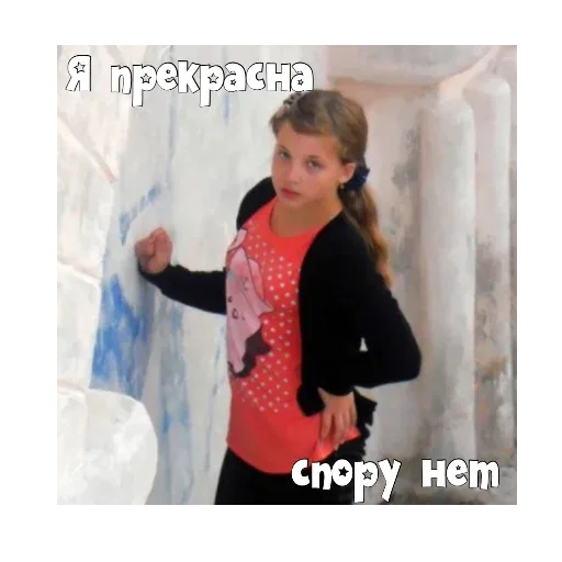 Девочка стоит в позе «модели» у стены, глядя в объектив. — девочка-подросток в оранжевой футболке