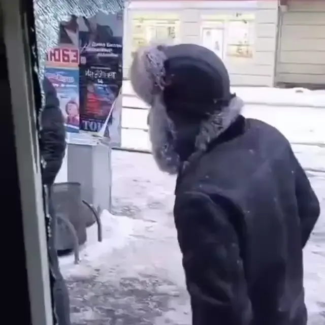 Мужчина в ушанке и разбитое стекло автобуса